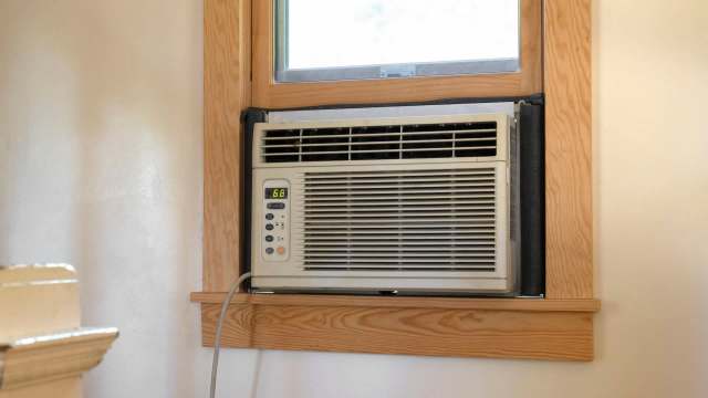 A window air conditioner set at 68 degrees Fahrenheit.