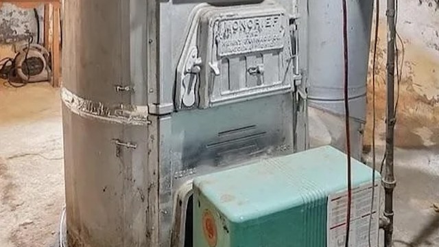 An old gravity furnace in an unfinished basement.