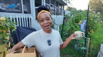 A woman standing in her garden.
