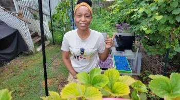 A woman standing in a garden.