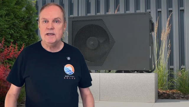 Gary Does Solar in front of an outdoor heat pump.