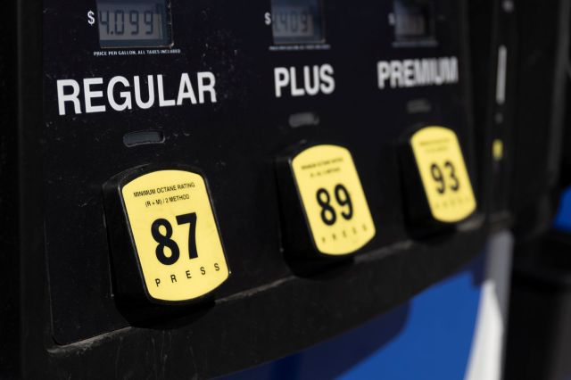 A fuel pump displaying prices for Regular, Plus, and Premium gasoline options.