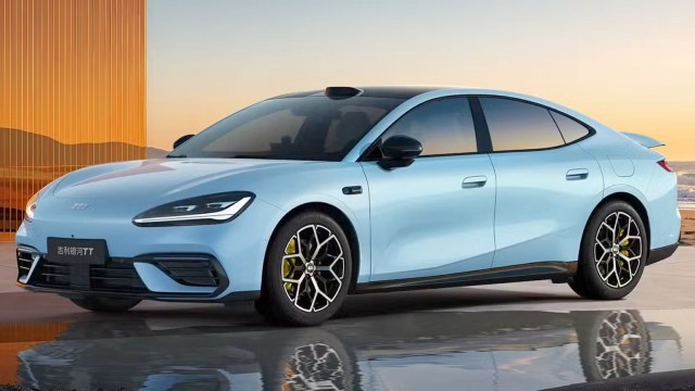 A sleek blue electric sedan parked against a sunset backdrop, showcasing modern design and stylish wheels.