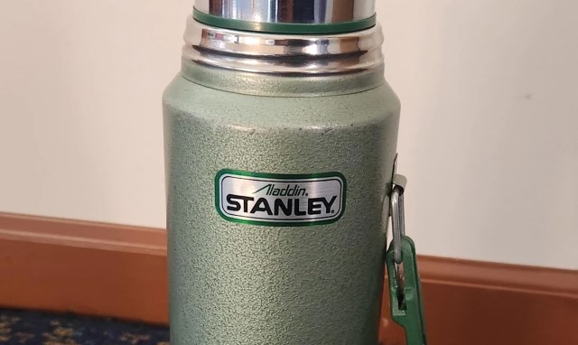 A green Aladdin Stanley thermos.