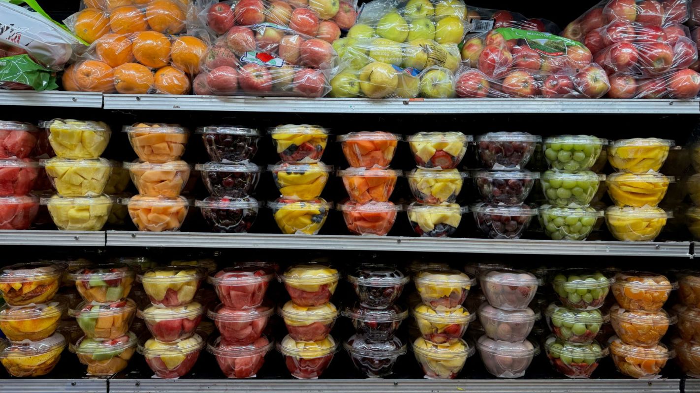 Fresh cut fruit on grocery store shelves.