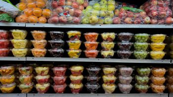 Fresh cut fruit on grocery store shelves.