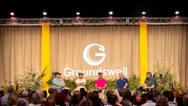 A panel of five speakers on stage at a Groundswell event.