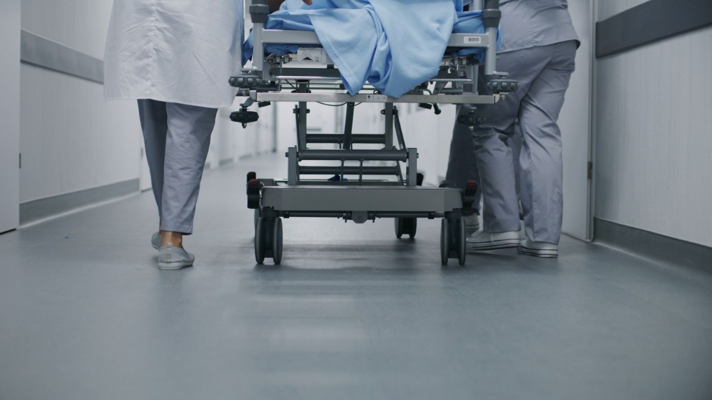 Medical professionals pushing a gurney.