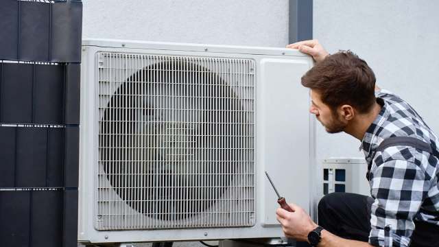 A person working on a heat pump.