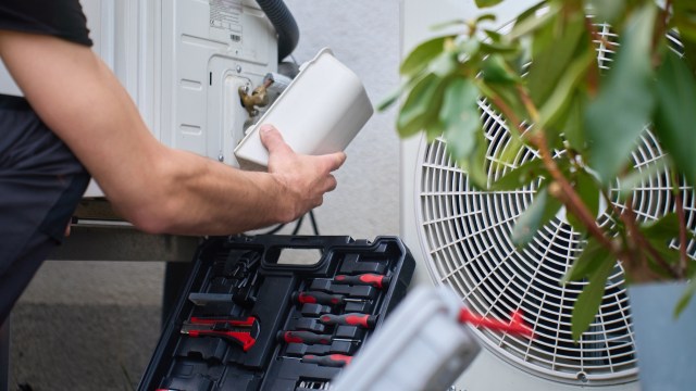 A person working on a heat pump.