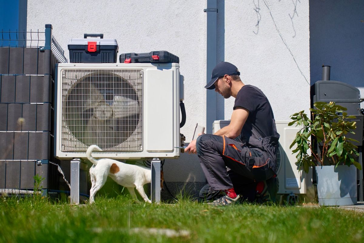 A person servicing a heat pump.