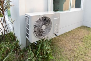 An outdoor air conditioning unit mounted beside a building.