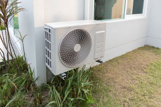 An outdoor air conditioning unit mounted beside a building.