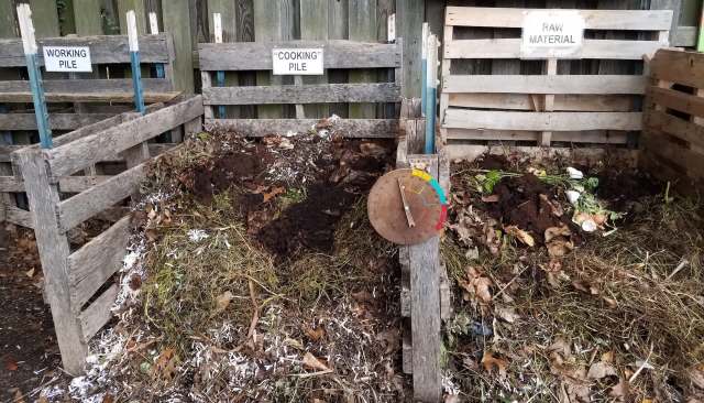 A composting system with labeled piles and a temperature gauge.