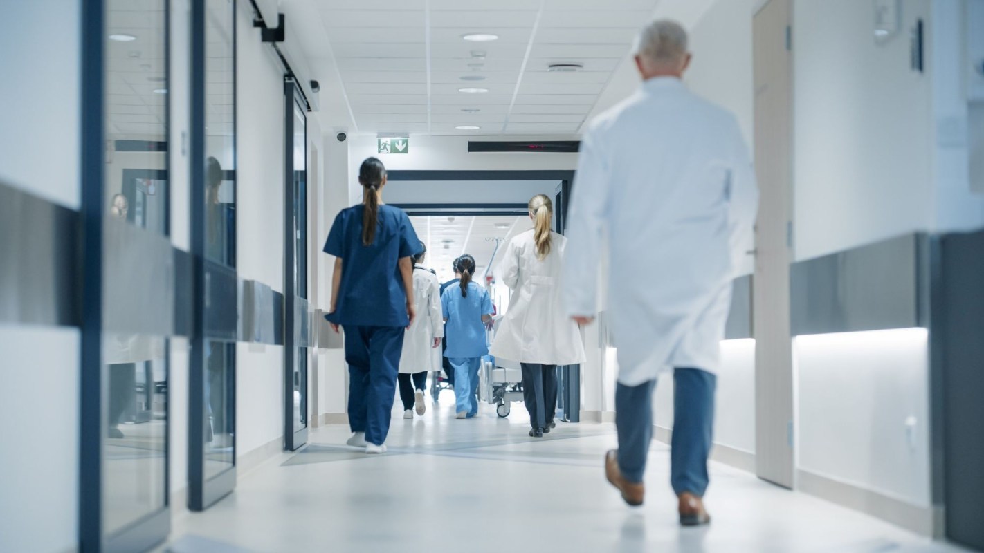 Doctors and nurses walking in a hospital hallway.