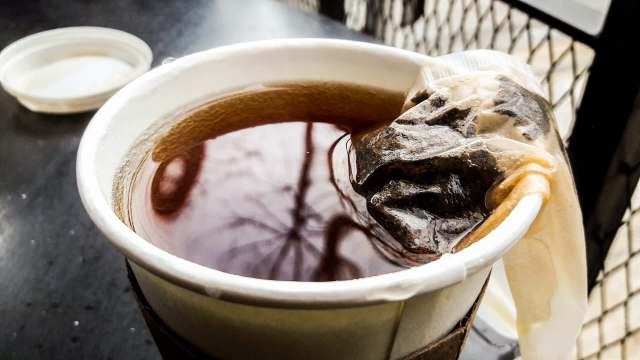 A tea bag steeping in a cup.