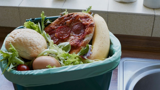 A trash bin with discarded food.