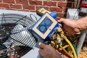 A worker doing maintenance on an HVAC unit.
