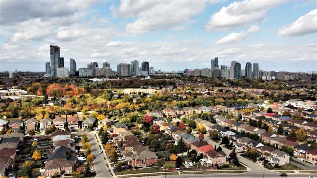Aerial view of a suburban neighborhood in front of a downtown skyline.