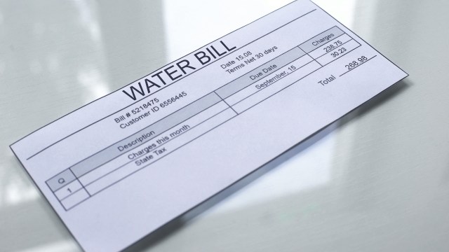 A printed water bill with details including charges, due date, and customer information.