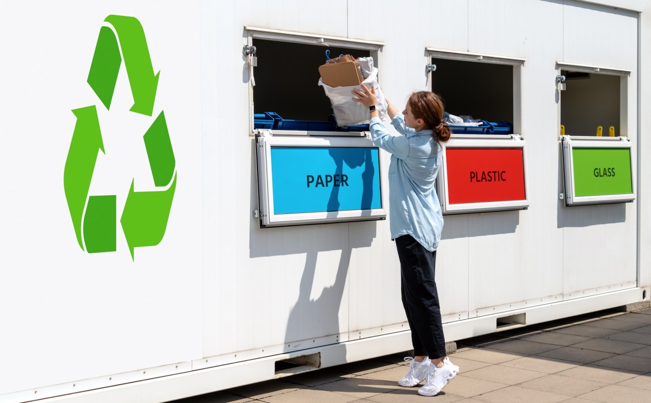 A woman drops off recyclables at a sorting station with labeled bins for paper, plastic, and glass.