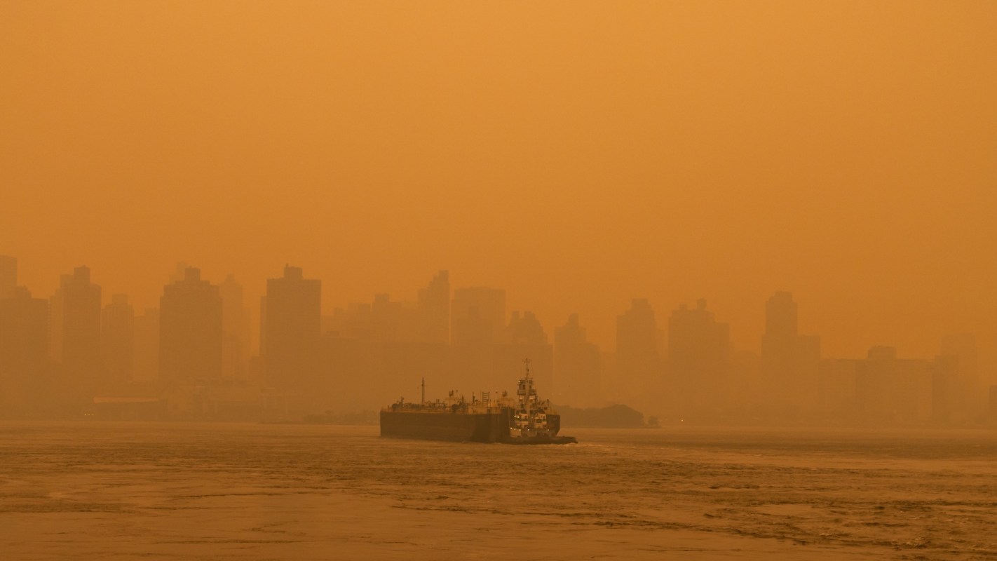 A cargo ship shrouded in hazy wildfire smoke.