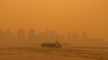 A cargo ship shrouded in hazy wildfire smoke.