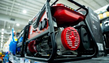 A close-up view of a red generator on display at a store with visible control A close-up view of a red generator on display at a store with visible control panel and engine details.and engine details.
