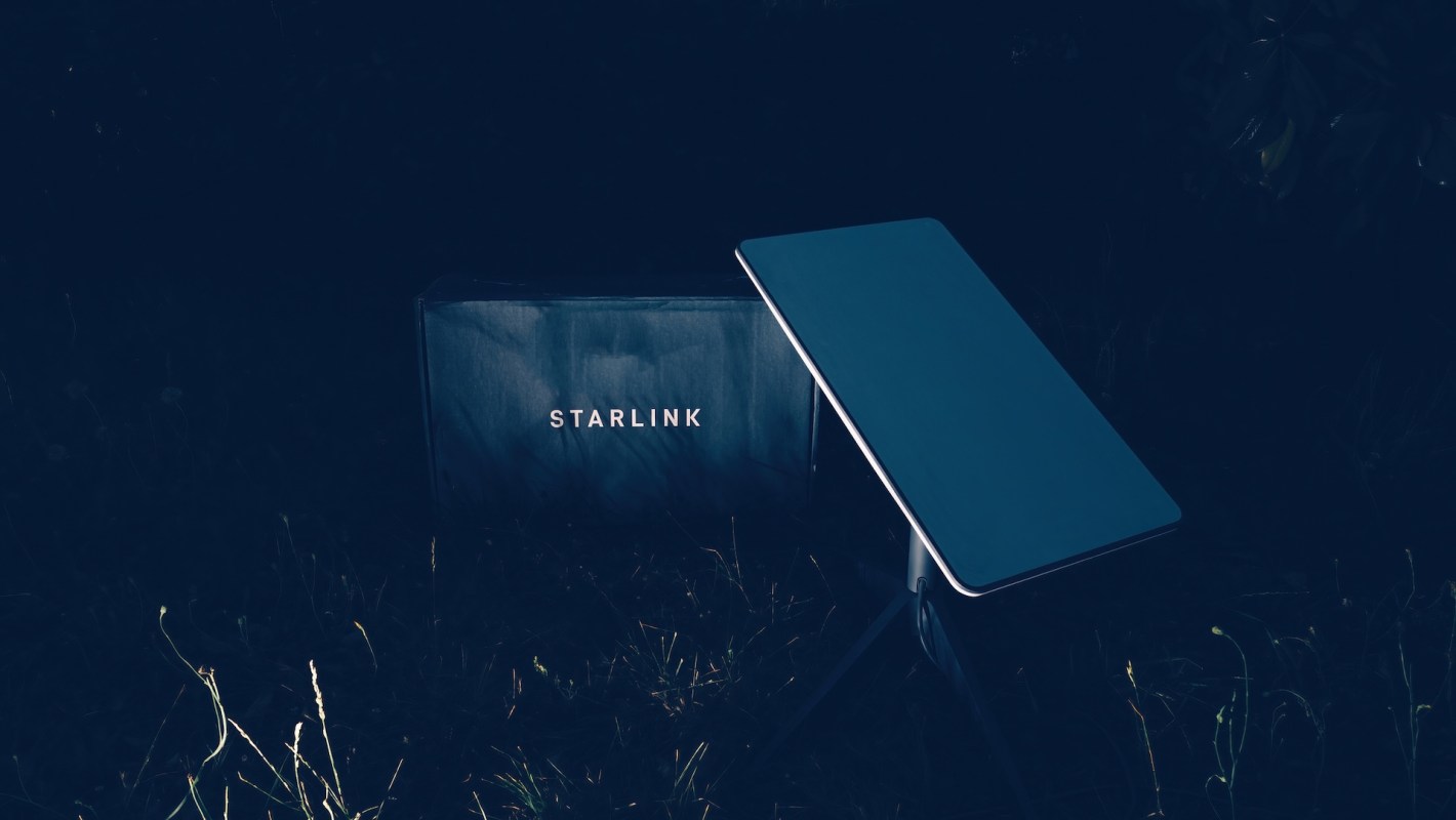 A Starlink dish and router in a dark outdoor setting.