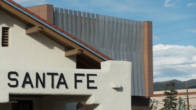 A close-up of a building sign that reads "SANTA FE" with modern architecture in the background.