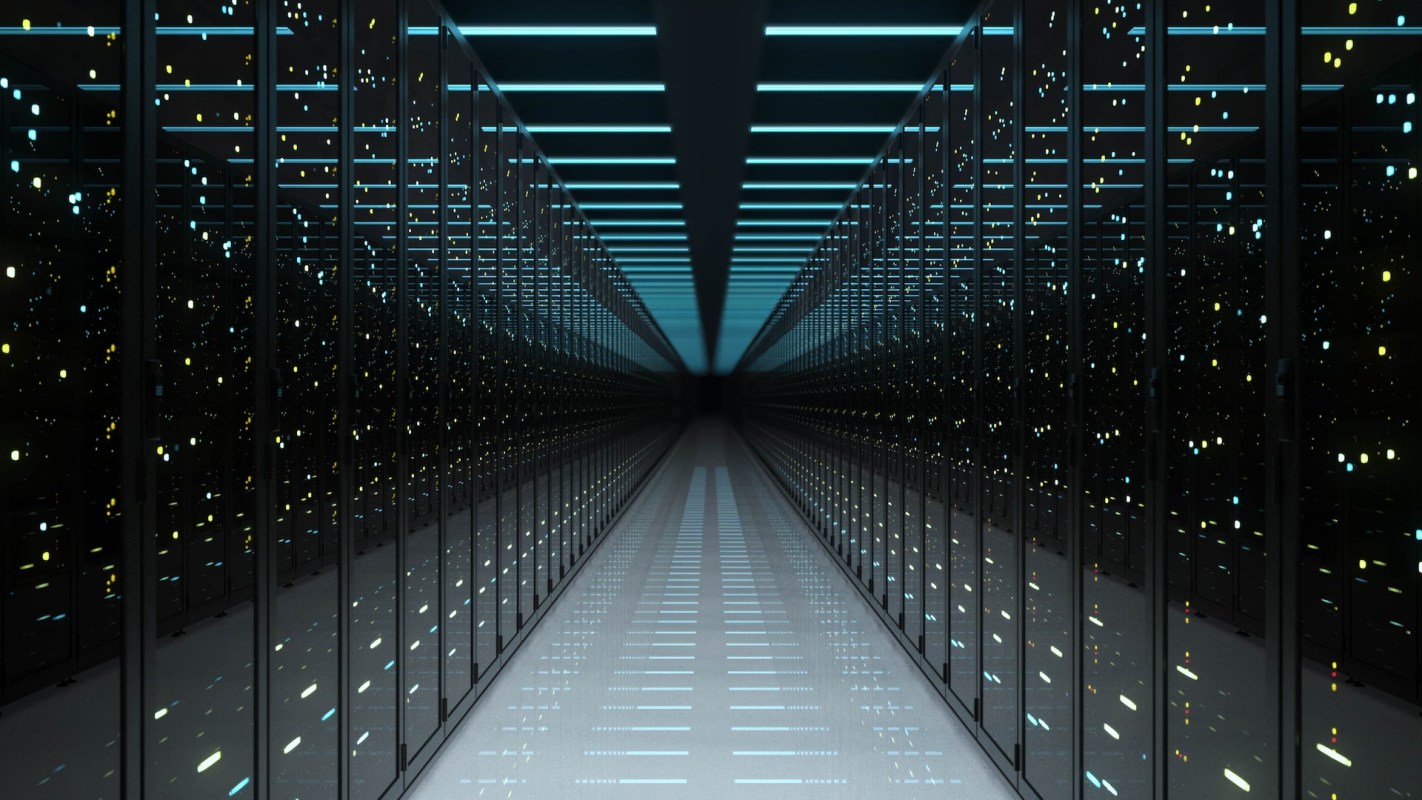 A narrow corridor lined with illuminated server racks.