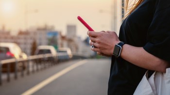 A person on a phone near traffic.