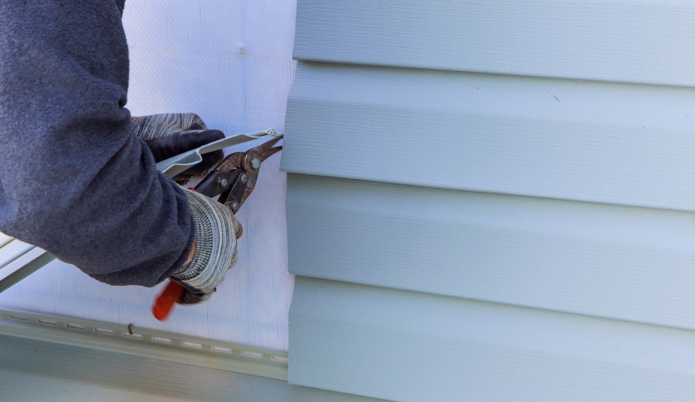 A person installing siding.