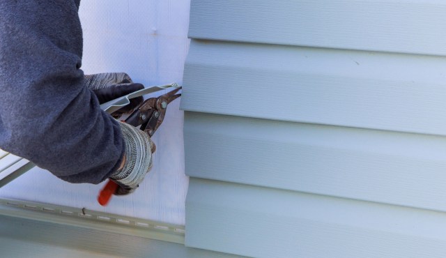 A person installing siding.