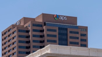 A close-up view of the APS building with a clear blue sky in the background.