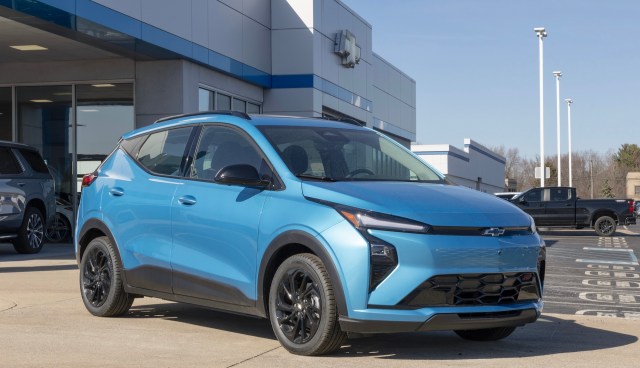 A blue Chevrolet Bolt electric vehicle outside a dealership.