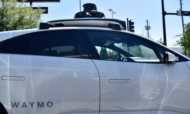 A Waymo self-driving car parked at an intersection, showcasing its automated features and sensors.