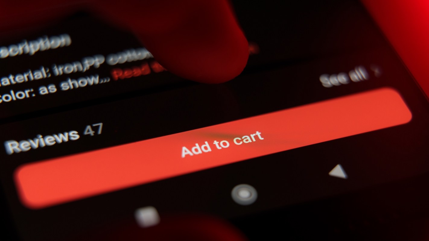A finger poised to click the "Add to cart" button on a smartphone screen displaying product details.