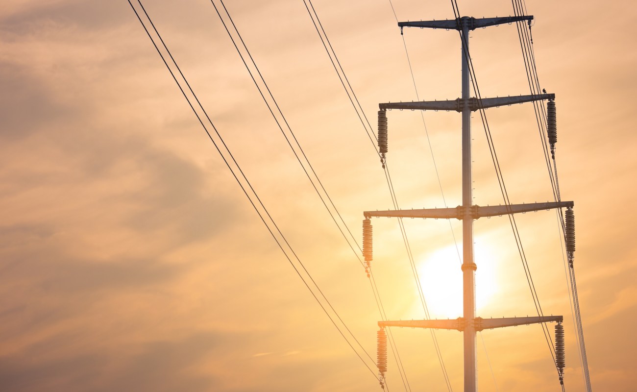 A silhouette of a transmission tower at sunset.