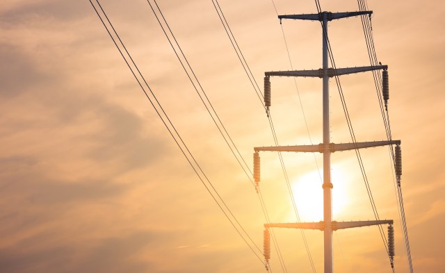 A silhouette of a transmission tower at sunset.