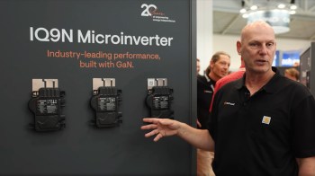 A presenter discusses the IQ9N Microinverter next to three displayed models at an industry event.