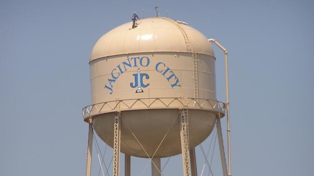 A water tower labeled "Jacinto City" with a person on top.
