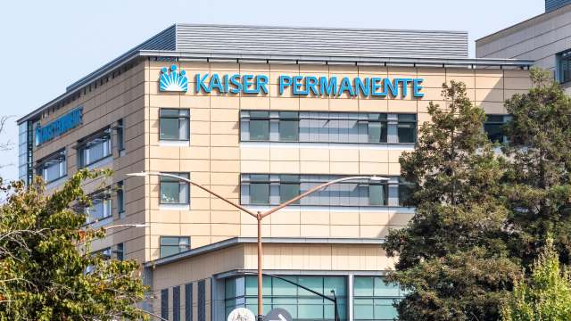 A street view of a modern building featuring the Kaiser Permanente logo and large windows.