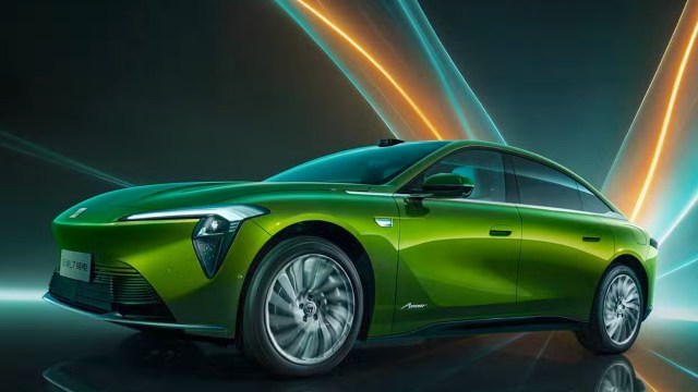 A green electric car with an illuminated background featuring dynamic lines and colors.