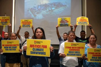 People hold up "Justice for climate survivors" signs.