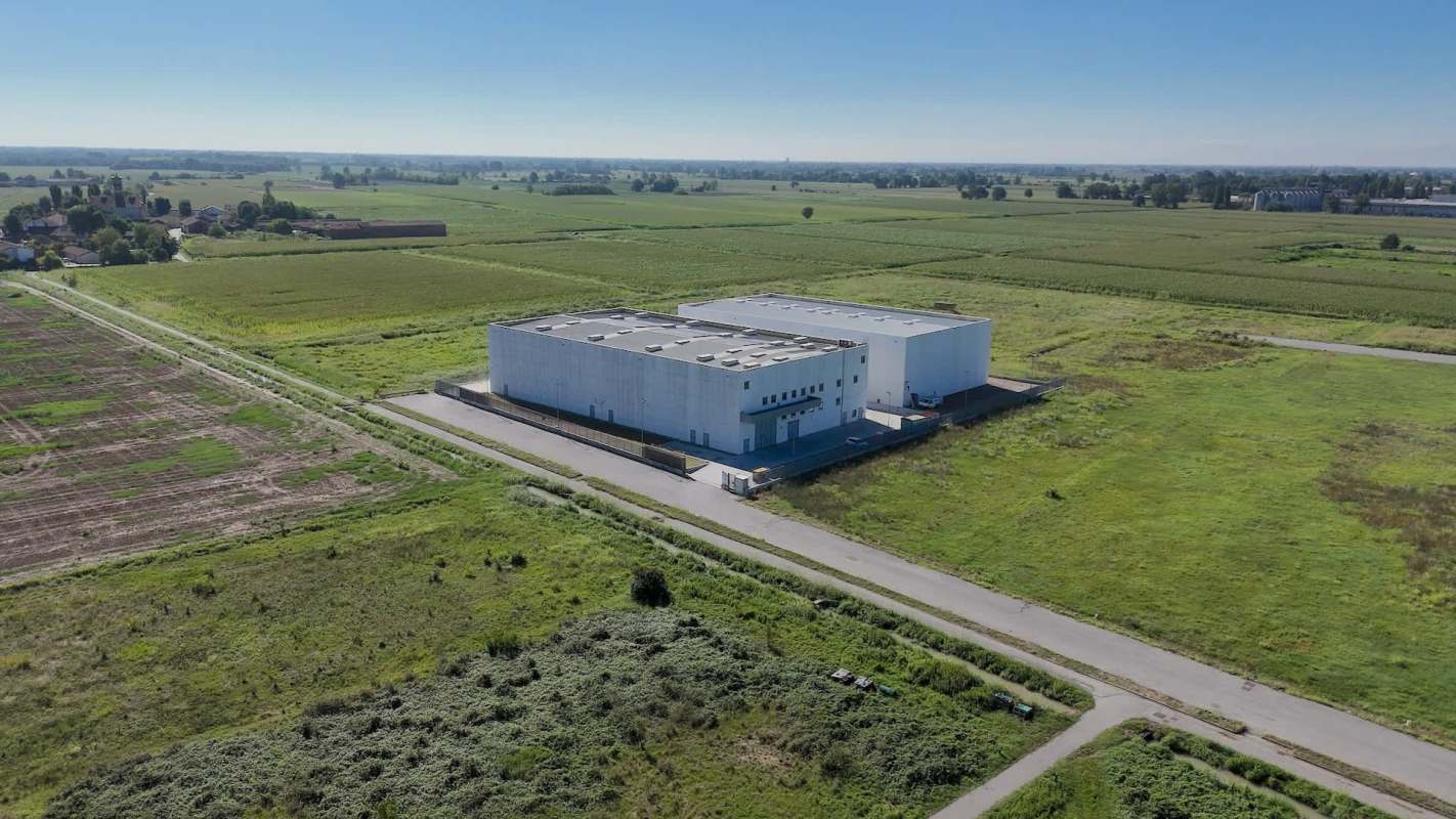 Aerial view of a data center surrounded by green fields and a rural landscape.