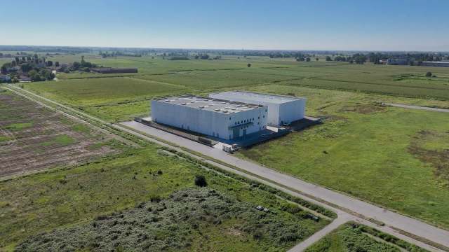 Aerial view of a data center surrounded by green fields and a rural landscape.