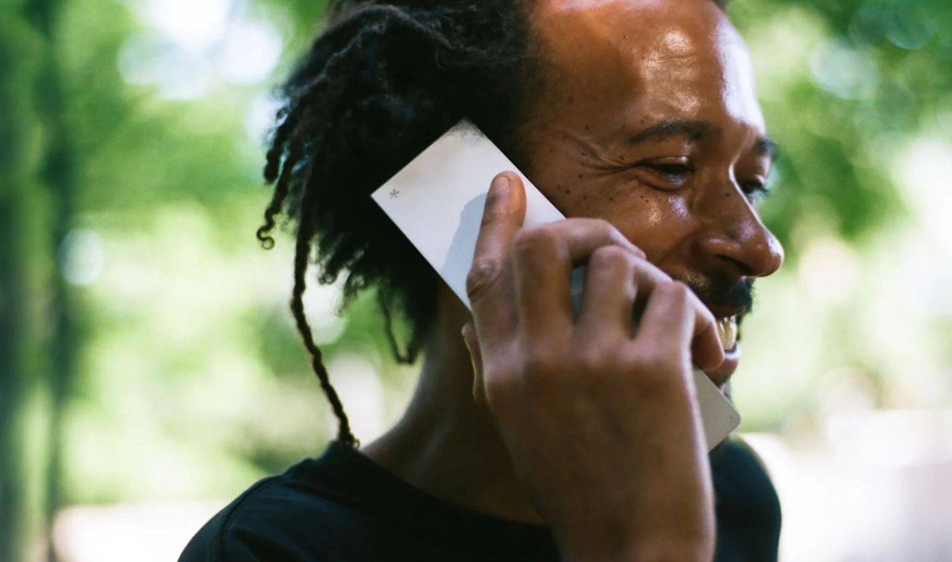 A man holding a Light Flip phone to his ear.