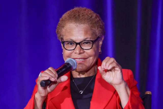 Los Angeles mayor Karen Bass speaking into a microphone while gesturing with her hands on stage.