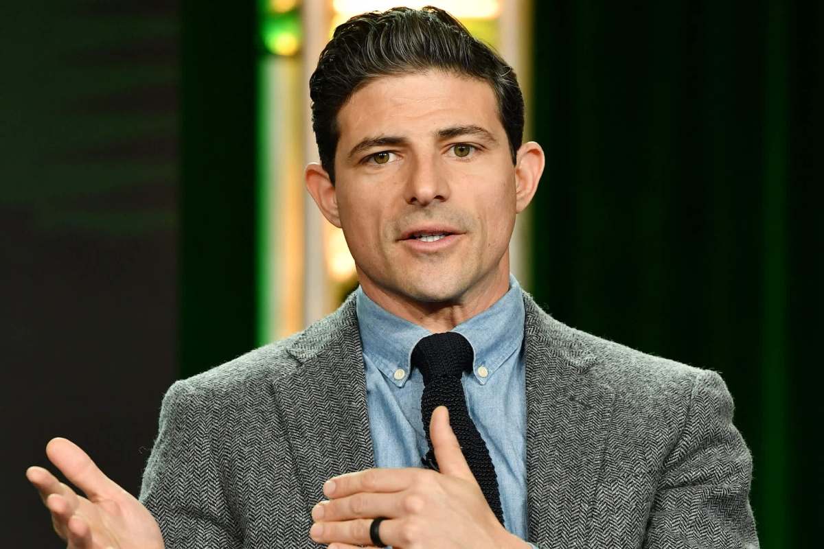 CBS News anchor Matt Gutman, in a gray blazer, speaks while gesturing with his hands.